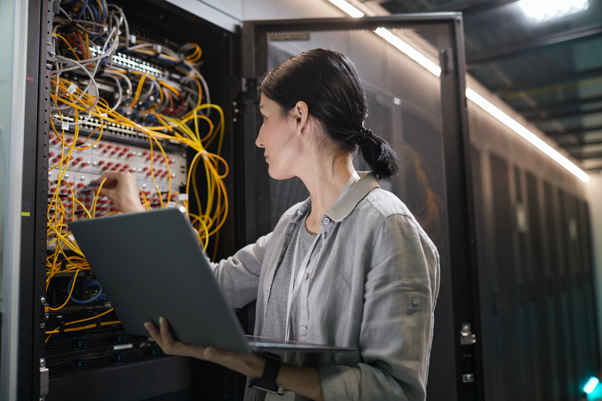 Female Network Technician Connecting Cables